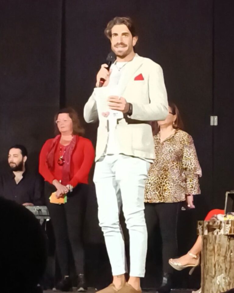 Davide Allegretta sul palco con il microfono durante un evento di formazione